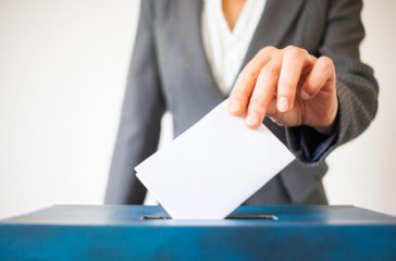 elections - The hand of woman putting her vote in the ballot box