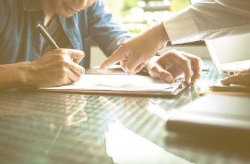 business partners signing contract to borrow money from investor to invest at own business.