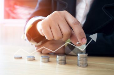 Woman putting coins on stack with holding money, Concept business, finance, money saving and investment