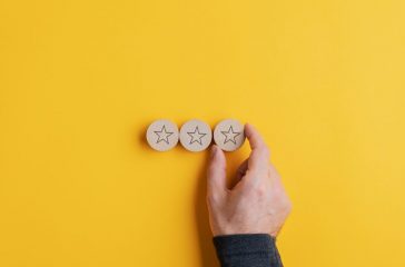 Placing three wooden cut circles with star shape on them in a row