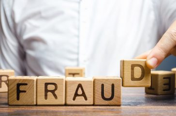 Wooden blocks with the word Fraud and man. Cheating white-collar . The crime. Theft of another's property. Anti-corruption in the financial sector. Deception and abuse of trust.