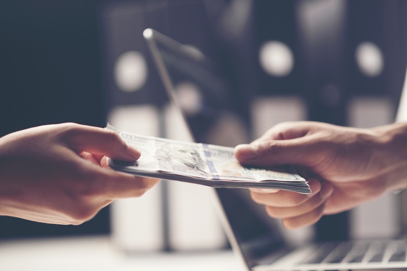 Close-up Of Person Hand Giving Money To Other Hand
