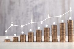 Coins on white table with profit graph.