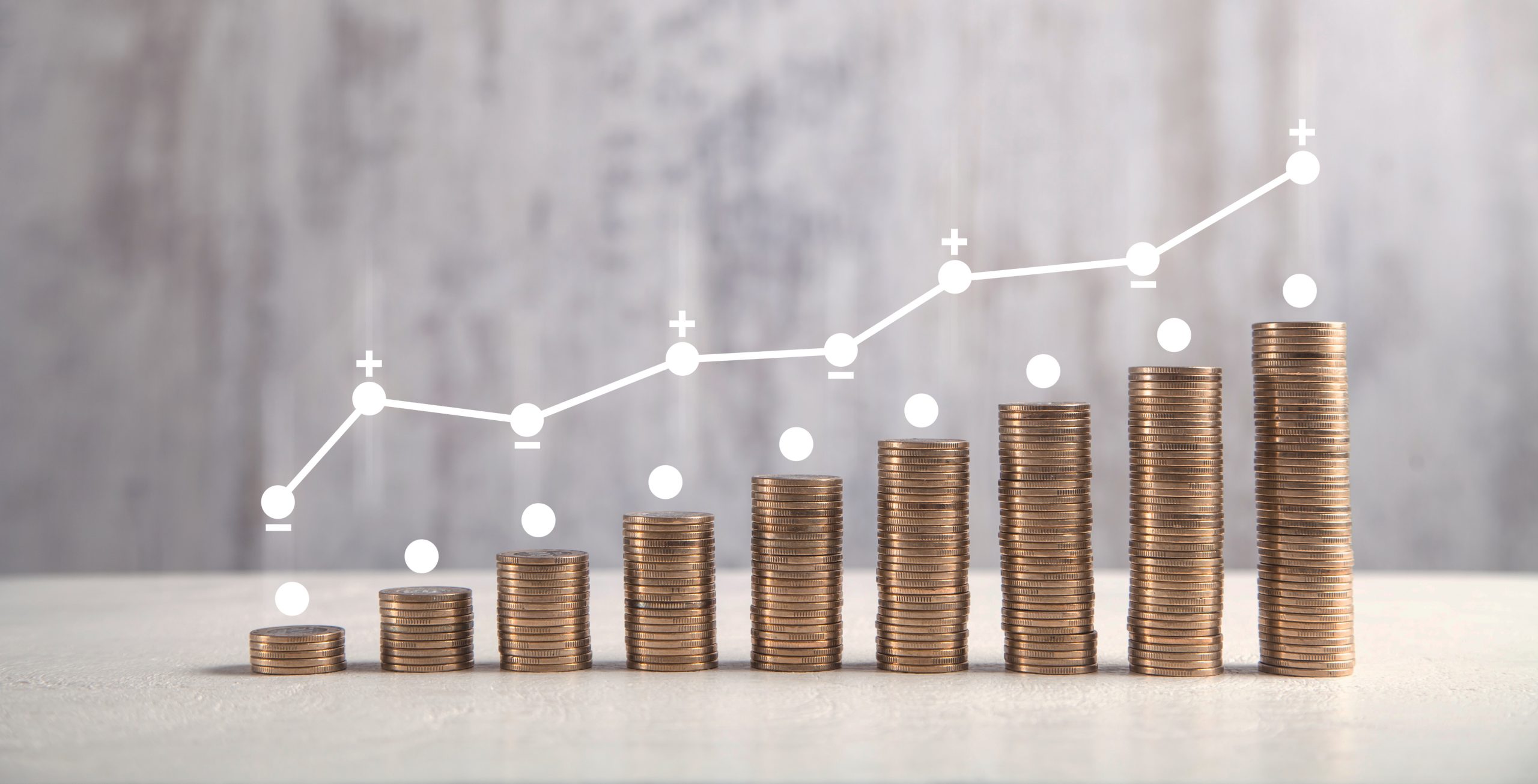 Coins on white table with profit graph.