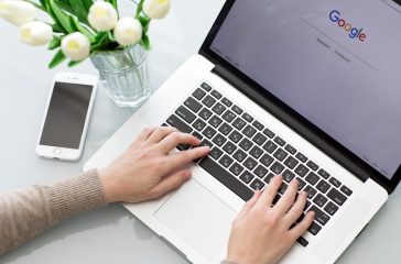 Woman hand MacBook Pro with social networking service Google