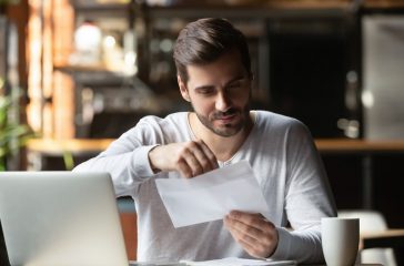 Male student open postal letter from college committee