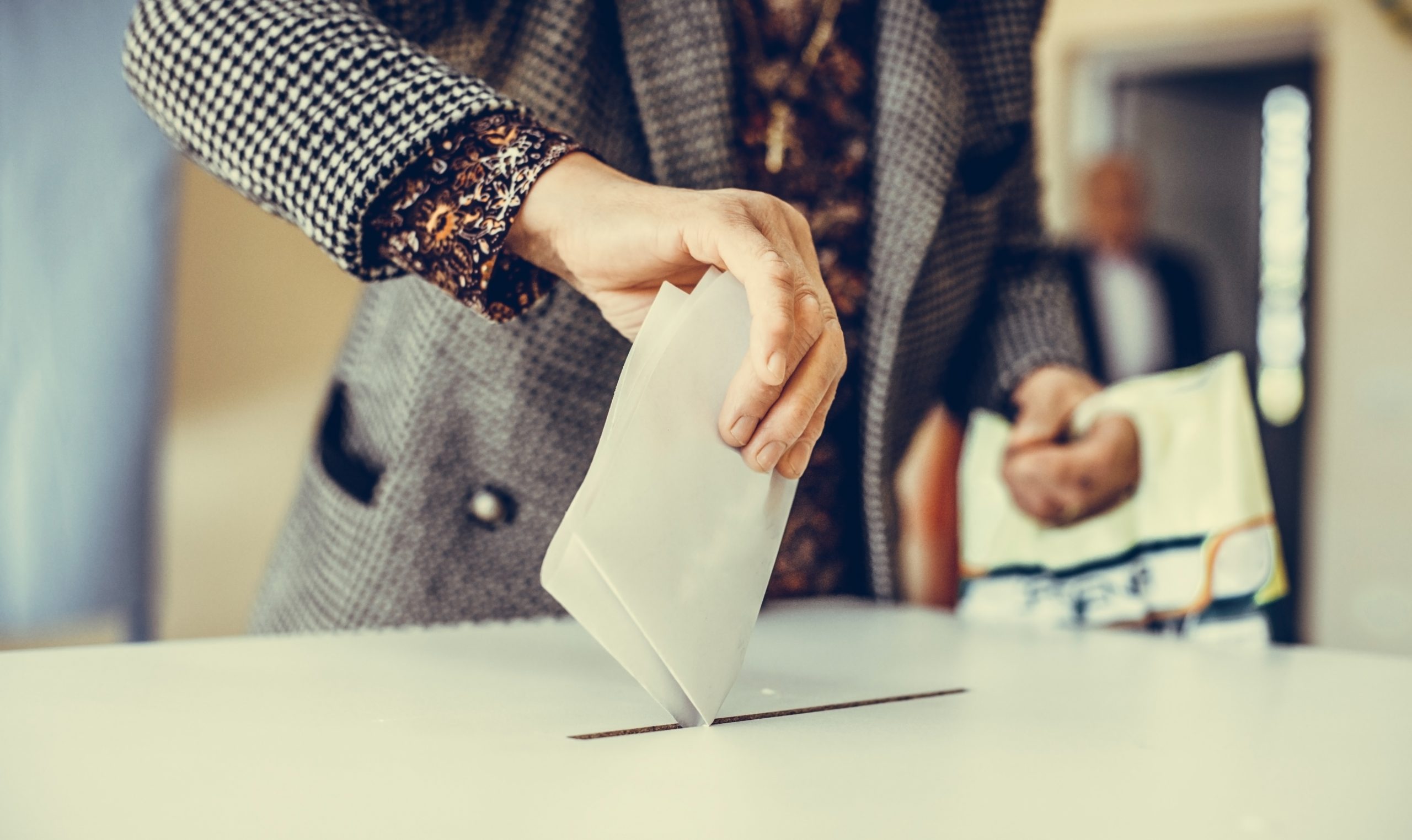 Person casting a ballot at a polling station