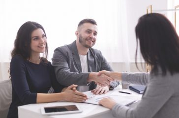 Young family handshaking with expert, ready to sign contract