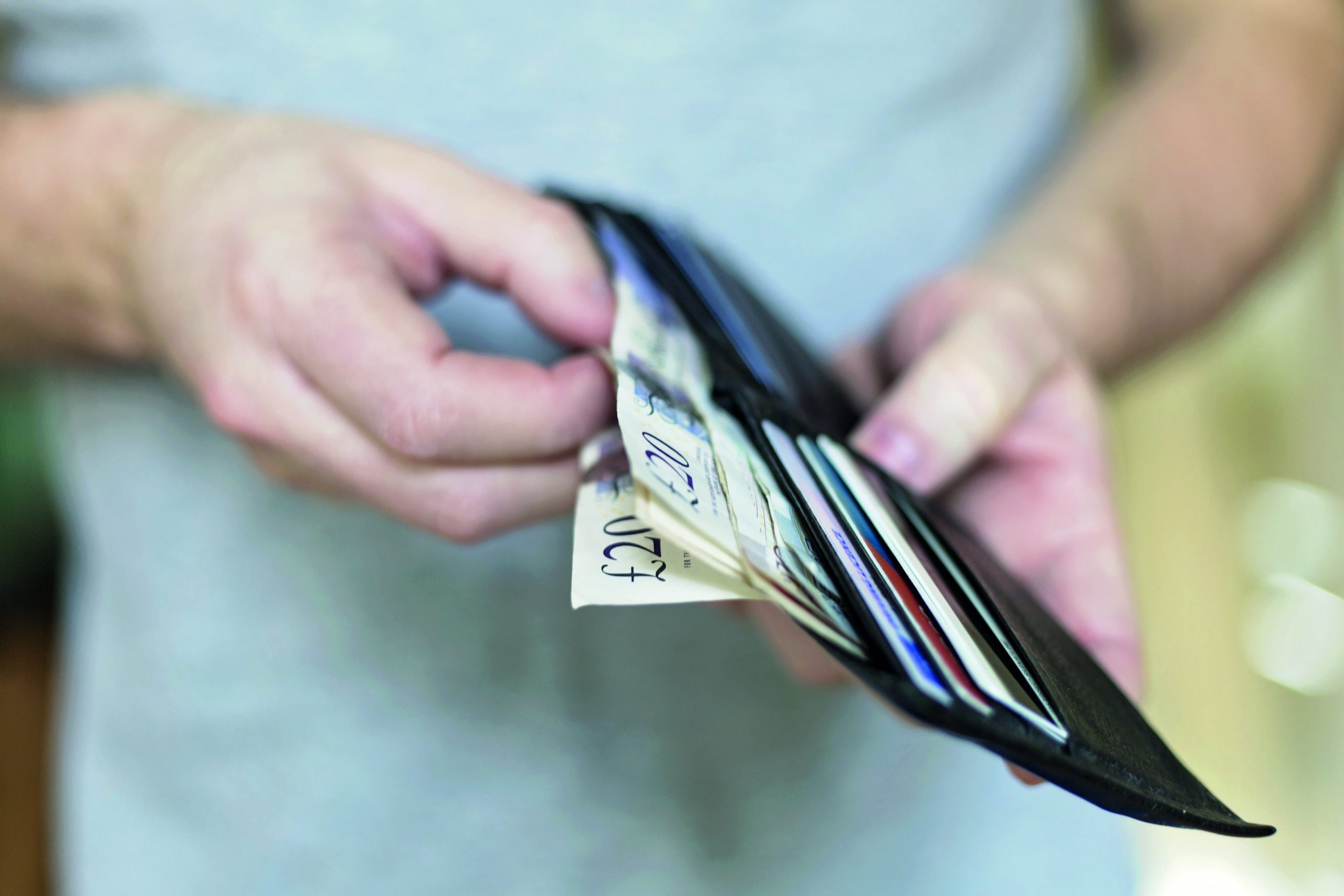 Man with cash inside wallet