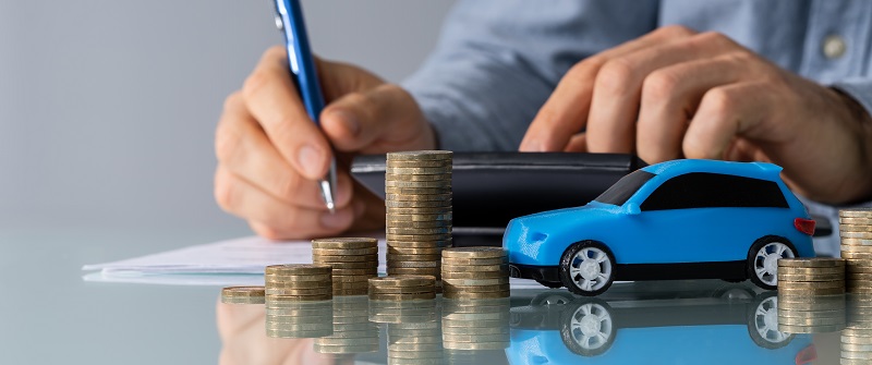 Toy Car In Front Of Businessman Calculating Loan