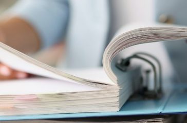 Woman examining information in folder with documents closeup