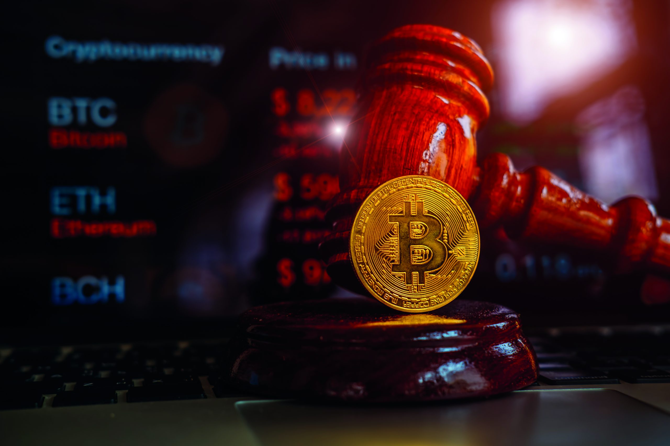 Law or auction gavel and bitcoins on a wooden desk, dark backgro