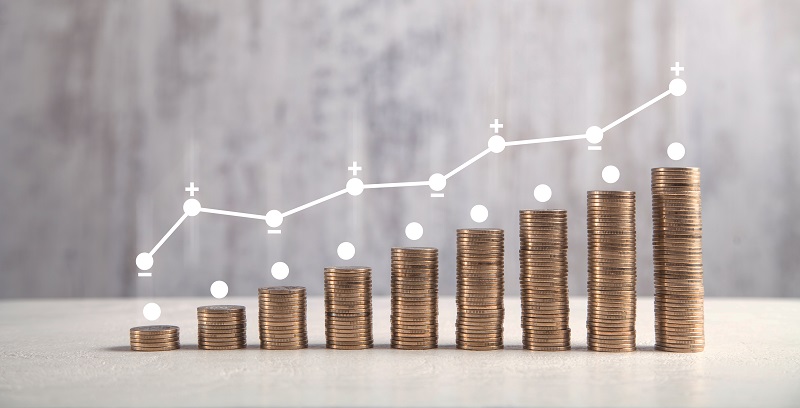 Coins on white table with profit graph.