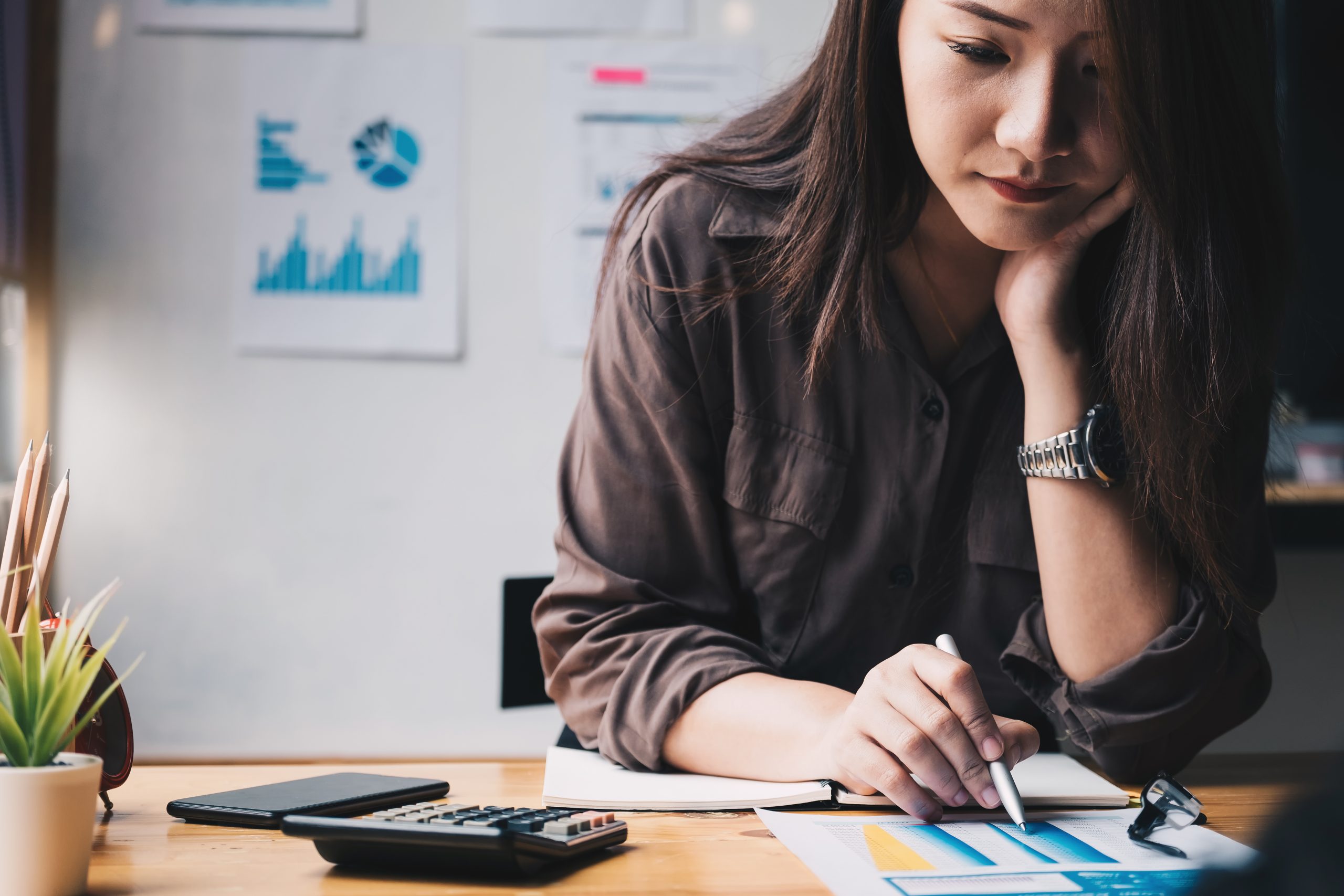Business woman using calculator for do math finance on wooden de